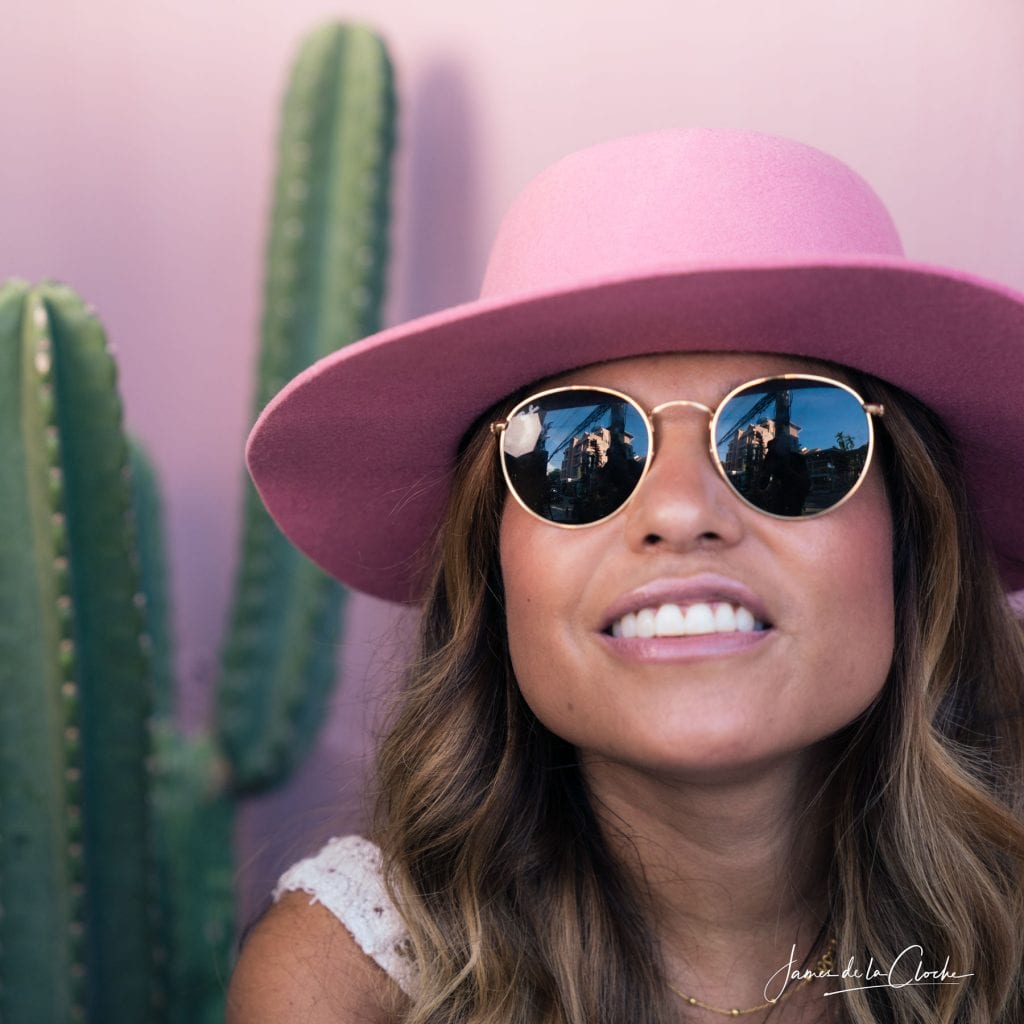 Girl in pink hat with Ray Ban's and pink background